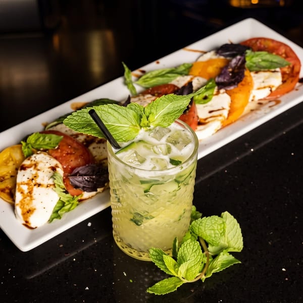 Caprese salad with red and yellow tomatoes, mozzarella, basil, and a cucumber mint cocktail.